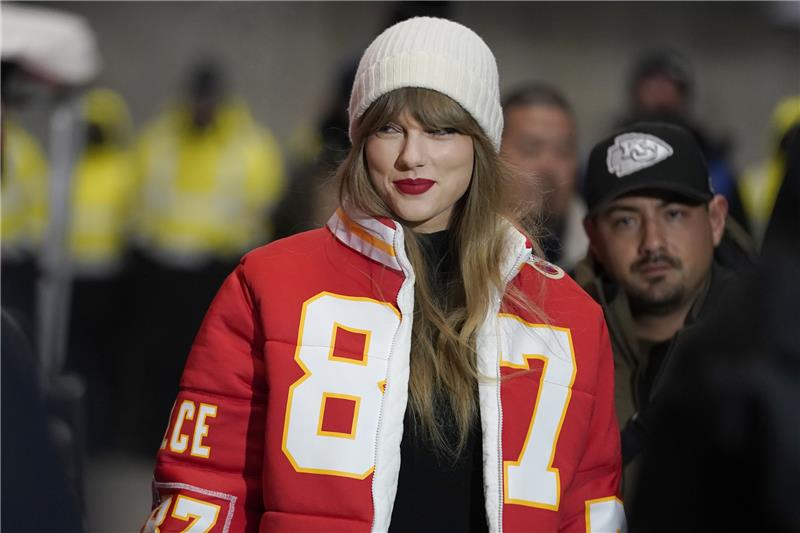 Taylor Swift trägt eine Jacke mit der Rückennummer von Kansas City Chiefs Tight End Travis Kelce. Foto: picture alliance/dpa/AP | Ed Zurga