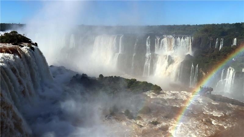 Ein Bild der Iguazu-Wasserfälle zwischen Argentinien und Brasilien, mit einem Regenbogen.
