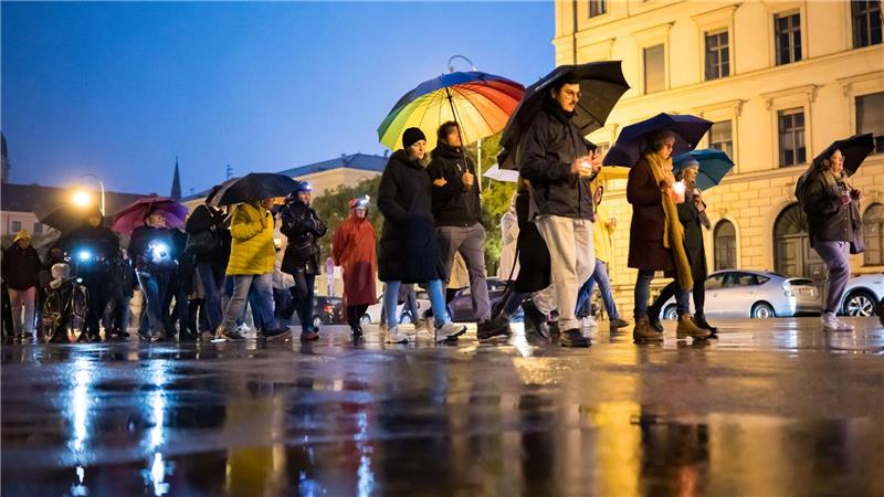 Teilnehmer des Schweigemarschs „Mach Dich auf für Menschlichkeit!“ gehen mit Kerzen auf der Ludwigsstraße in München.