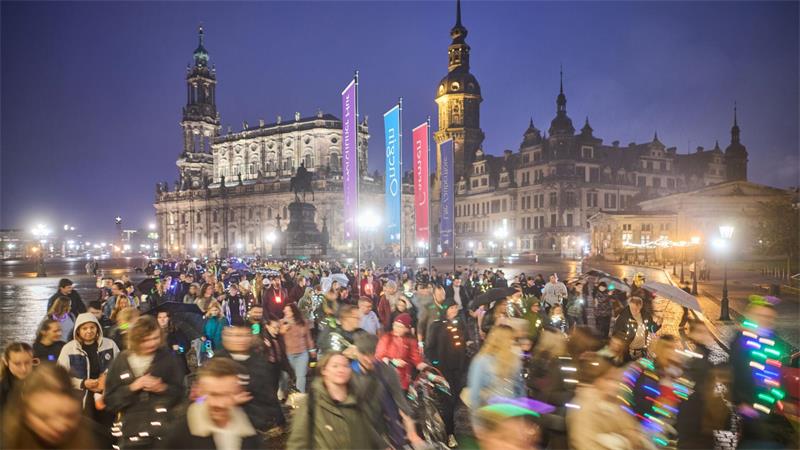 Teilnehmer des Spazierclubs Dresden laufen am Abend über den Theaterplatz.