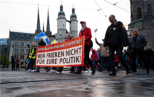 Teilnehmer einer Demonstration des Bündnisses „Bewegung Halle“ ziehen durch Halle/Saale.