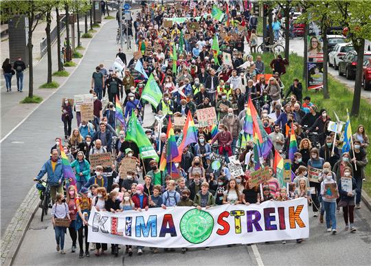 Teilnehmer eines Demonstrationszuges von Fridays for Future tragen ein Banner mit dem Text «Klimastreik». Foto: Christian Charisius/dpa