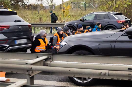 Teilnehmer eines Klimaprotests blockieren auf der A113 kurz vor der Ausfahrt zum Flughafen Berlin Brandenburg (BER)«„Willy Brandt» den Verkehr.