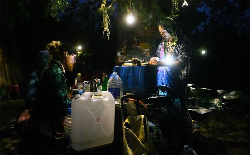 Teilnehmer kochen Essen bei einem Zeltlager.