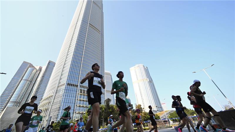 Teilnehmer von dem Hongkong-Marathon laufen durch die Innenstadt.