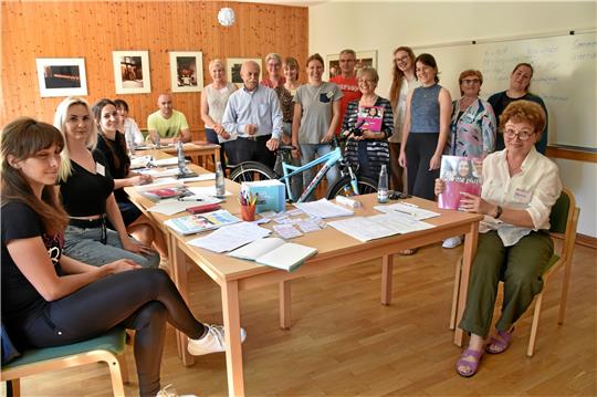 Teilnehmerinnen und Freiwillige im Deutschkurs für Ukrainerinnen. Heute gibt es ein Fahrrad als Überraschung.  Foto: Hartmann