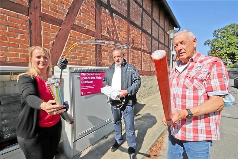 Telekom-Regio-Managerin Sabine Köhler und Othfresens Ortsbürgermeister Harald Fricke (re.) präsentieren zum Ausbaustart die Glasfaserkabel-Varianten, Dieter Schulz, Leiter Produktionssupport Technik Nord bei der Telekom, die Hausanschluss-Box.