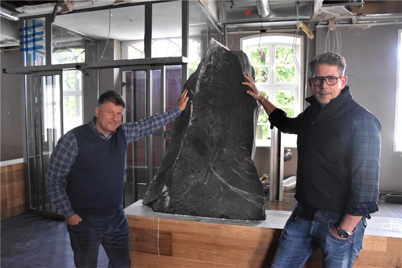 Nach Deckeneinsturz: Das „Schiefer“ öffnet erst 2024 wieder Tescom-Chef Holger Holste (links) und „Schiefer“-Betreiber Alexander Scharf betonen, dass sie das Lokal am Marktplatz möglichst schnell wieder aufbauen wollen. Den Felsbrocken, der den Deckeneinsturz im September überlebte, sehen beide als Sinnbild für gemeinsamen Optimismus. Foto: Roß