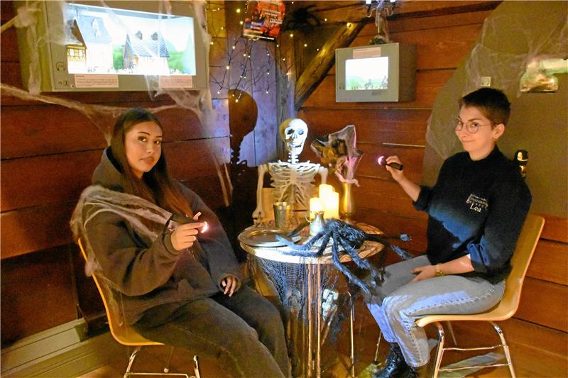 Tête-à-Tête mit einem Skelett? Kori Jara Romero (links) und Lea Knupper nehmen schon mal Platz – und laden ein, das gruselig dekorierte Zinnfigurenmuseum an Halloween von 18 bis 21 Uhr mit Taschenlampen zu erkunden. Foto: Kempfer