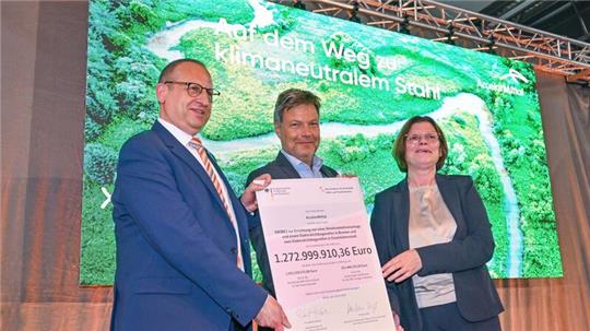 Thomas Bünger (l-r), CEO von ArcelorMittal, Robert Habeck (Grüne), Bundeswirtschaftsminister und Kristina Vogt (Die Linke), Bremer Senatorin für Wirtschaft, zeigen einen Fördermittelbescheid.