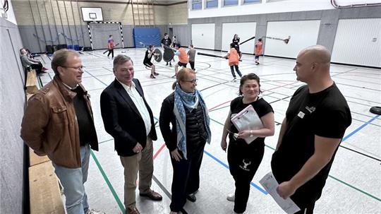Thomas Kregel, Hans-Heinrich Haase-Fricke und Miriam Bartels (v.l.) lassen sich in der WvS-Turnhalle von Erna Lemke und Florian Hinz das Jugger-Konzept erklären und von den Jugendlichen (im Hintergrund) auch zeigen.