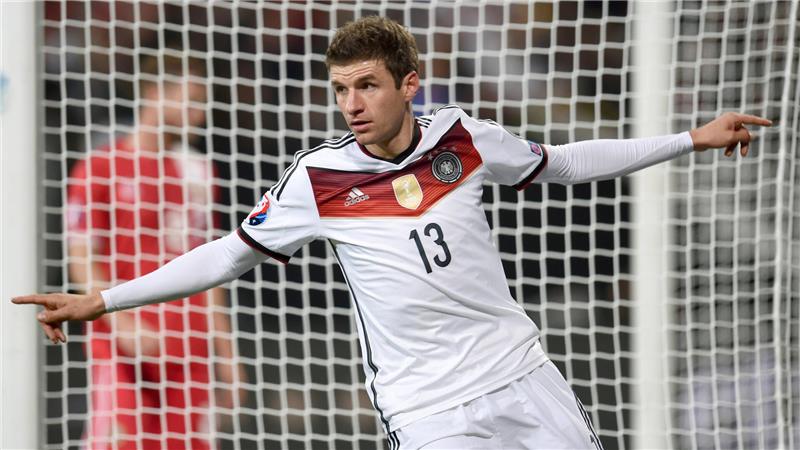 Das Foto zeigt den Fußballspieler Thomas Müller mit der Nummer 13 auf dem Trikot der deutschen Nationalmannschaft. Müller jubelt mit ausgebreiteten Armen über ein Tor.