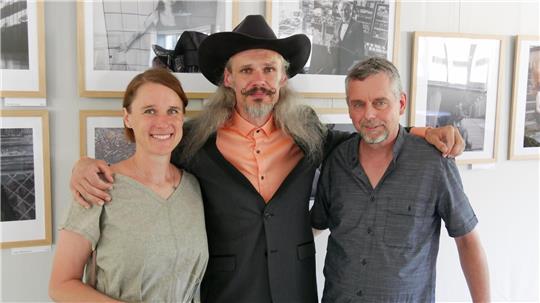 Thomas Velte, Vorsitzender des BBK (rechts), Künstler Michal „Whitte Charles“ Bauer Pticen und Dolmetscherin Markéta Kelnerova präsentieren die Ausstellung im Kulturmarktplatz.