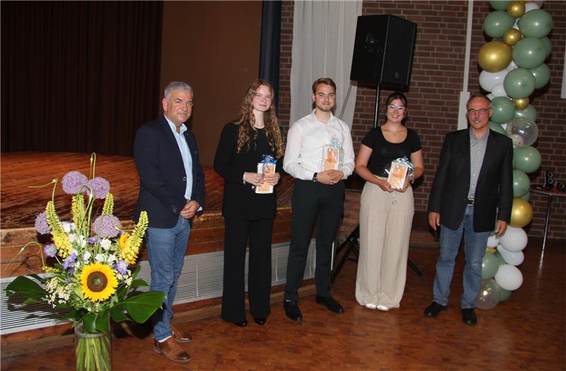 Zwölf Abiturienten feierlich aus der AGG Oker entlassen Thorsten Röpke (li.) und Jens Kloppenburg (re.) beglückwünschen Lena Hillebrand (v.li.), Jonas Eggers und Lotta Nähring für guten Abi-Durschnitt und Engagement. Foto: Hohaus