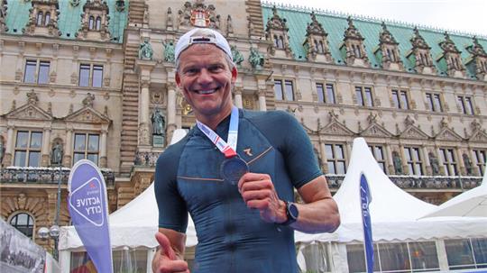 Thorsten Schröder zeigt nach der Triathlon-Weltmeisterschaft seine Medaille.