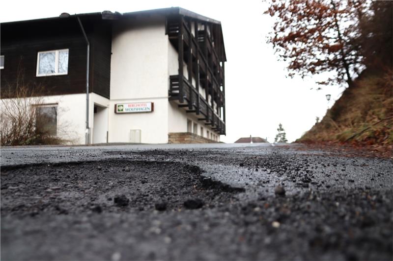 Tiefe Krater zeigen sich an der Auffahrt zum leer stehenden Berghotel an der Heimbergstraße und die Wintermonate werden sicher weiter am Asphalt der Straße nagen. Foto: Neddermeier