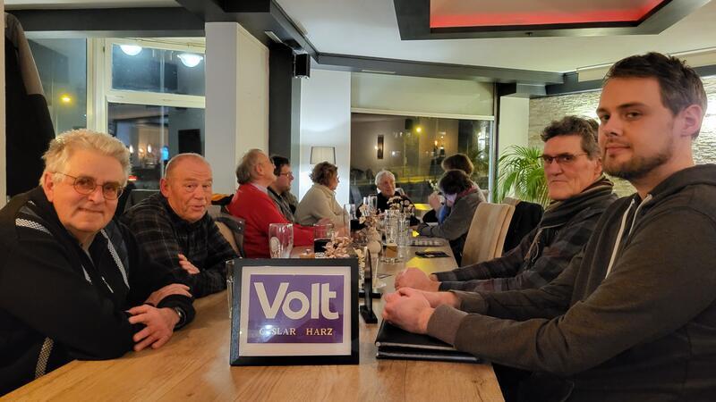 Tim Peters (r.) stellt den Besuchern im „Papilion“ die neue Volt-Ortsgruppe in Goslar vor.