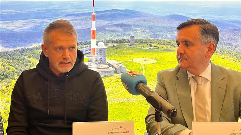 "Timberjacks"-Geschäftsführer Thomas Kemner (l.) stellt mit Landrat Thomas Balcerowskiaus Halberstadt die Pläne für die "Timberjacks Mountain Lodge" auf dem Brocken vor.