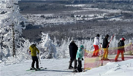 Das Foto zeigt Skifahrer mit einem tollen Panoramablick.