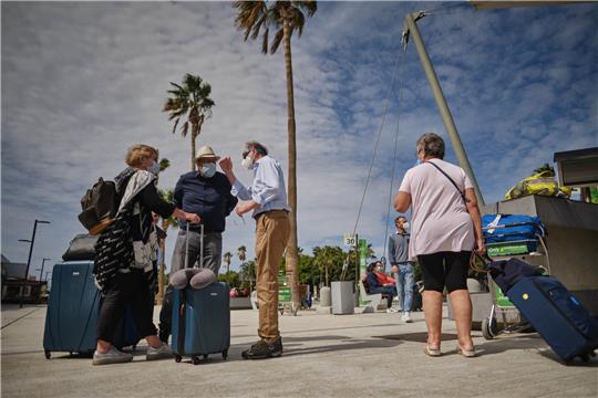 Touristen am Flughafen von Teneriffa: In Spanien macht sich die Ausbreitung der BA.5-Variante in den Kliniken bemerkbar. Foto: PA/dpa