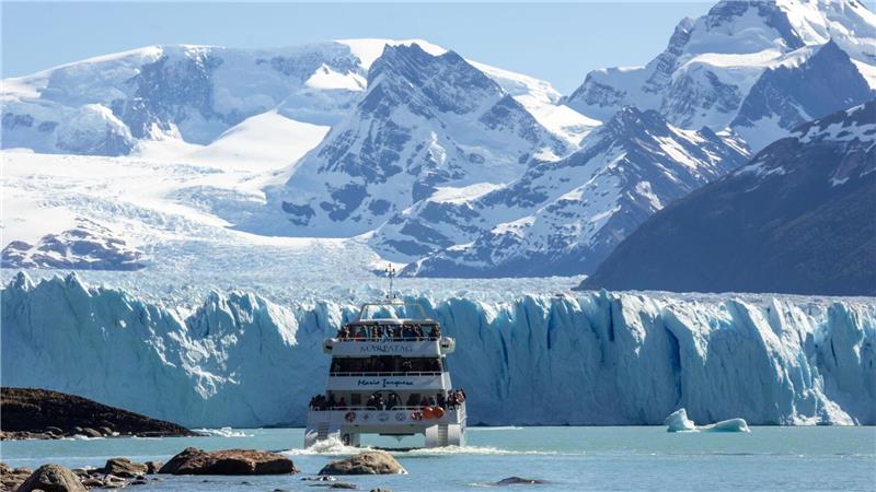 Touristen fahren durch den Lago Argentino an den Gletscher Perito Moreno.