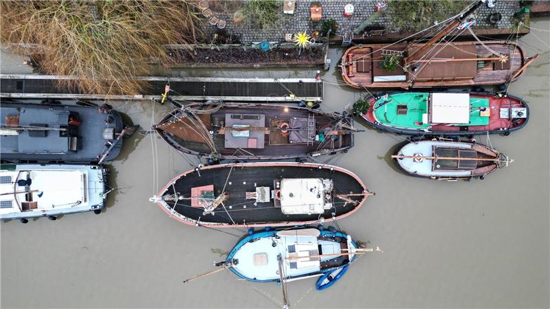 Traditionsschiffe liegen im grauen Wasser im Hafen von Leer.