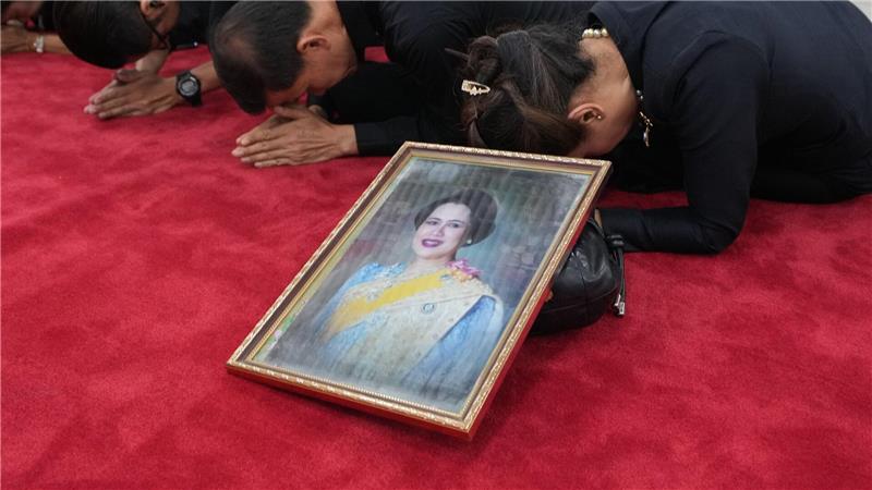 Trauernde beten in Bangkok mit einem Porträt der Königinmutter Sirikit.