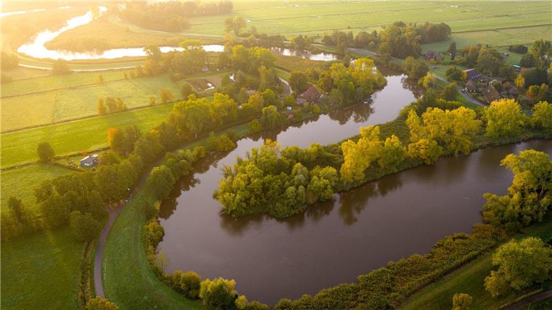 Traumlandschaft: Die Wümme fließt im Bremer Blockland vorbei an Bäumen, die bereits Herbstfarben tragen. 