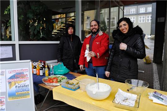 Trotz Regenwetters gehen die Falafel von Hasan Asfour (Mitte) und seinen Freunden ruckzuck weg: Nach einer halben Stunde ist alles ausverkauft. Foto: Ernst