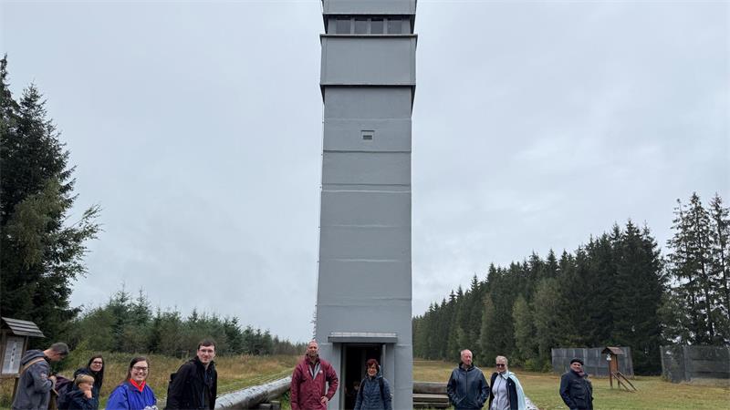 Das Foto zeigt mehrere Menschen vor einem Turm.