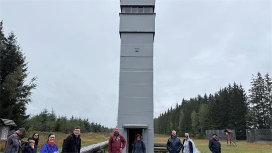 Das Foto zeigt mehrere Menschen vor einem Turm.