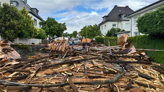 Trümmer des Kirchturmdaches liegen auf der Straße: Der Dachstuhl wurde nun völlig zerstört.