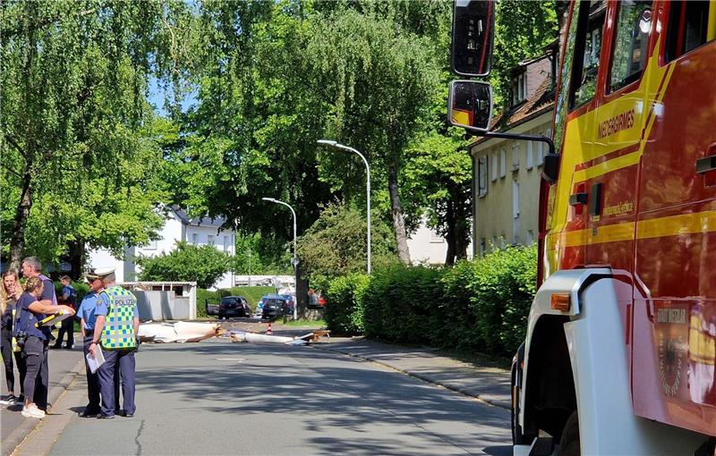 Trümmer liegen auf der Straße nach dem Absturz eines Leichtflugzeugs im Stadtgebiet von Wetzlar.