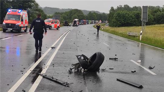 Trümmerteile liegen an der Anschlussstelle Lutter auf der Fahrbahn der B 82. Die Straße ist wegen des Unfalls voll gesperrt, der Verkehr staut sich.
