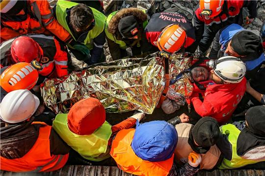 Türkische Rettungskräfte tragen den 60-jährigen Eyup Ak in Adiyaman zu einem Krankenwagen, nachdem sie ihn 104 Stunden nach dem Erdbeben lebend aus einem eingestürzten Gebäude geborgen haben.