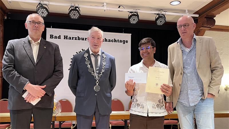 Turnierleiter Jörg Baars (l.), Bürgermeister Ralf Abrahms (2.v.l.) und der Präsident des Niedersächsischen Schachverbandes Michael Sebastian Langer (r.) küren den Turniersieger Arun Kataria.
