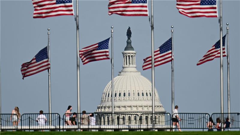 US-Fahnen wegen am Washington Monument. Im Hintergrund ist die Kuppel des US-Kapitols zu sehen.