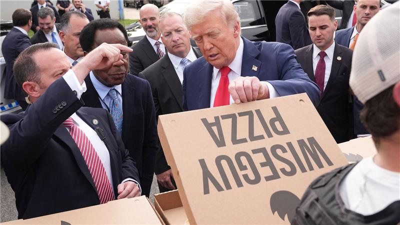 Bilder des Tages US-Präsident Donald Trump schaut sich eine Pizza an, während er sich mit Mitgliedern von Strafverfolgungsbehörden und Soldaten der Nationalgarde in Washington trifft.