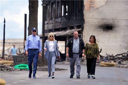 US-Präsident Joe Biden (l) und First Lady Jill Biden (2.v.l) gehen zusammen mit Josh Green, Gouverneur von Hawaii, und seiner Frau Jaime Green durch ein von Waldbränden auf der Insel Maui verwüstetes Gebiet.