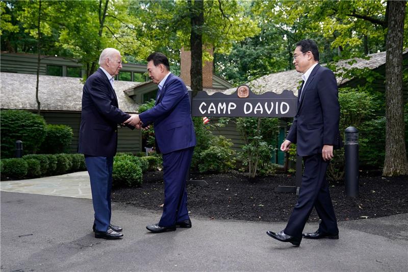 USA, Japan und Südkorea wollen „Botschaft an Welt” senden US-Präsident Joe Biden (l)begrüßt seine Gäste zum Gipfel in Camp David.