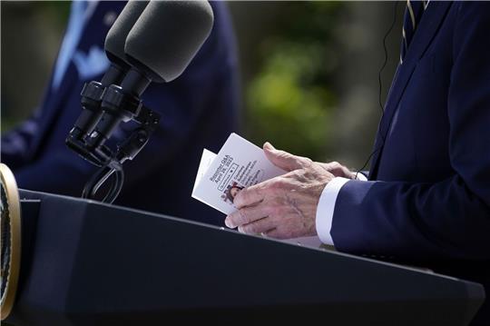 US-Präsident Joe Biden schaut während der Pressekonferenz im Rosengarten des Weißen Hauses auf seine Notizen.