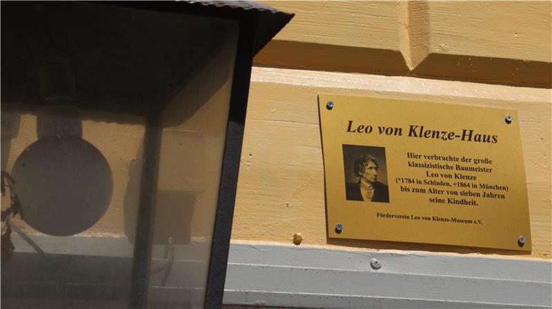 Eine goldene Tafel an einer Hausfassade mit den Lebensdaten Leo von Klenzes.