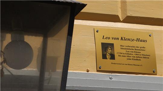 Eine goldene Tafel an einer Hausfassade mit den Lebensdaten Leo von Klenzes.
