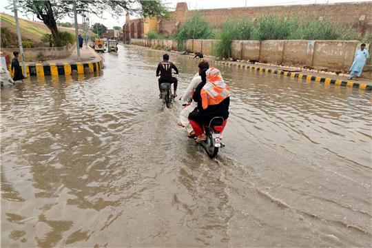 Überall Wasser: Menschen fahren durch überschwemmte Straßen nach starkem Monsunregen.