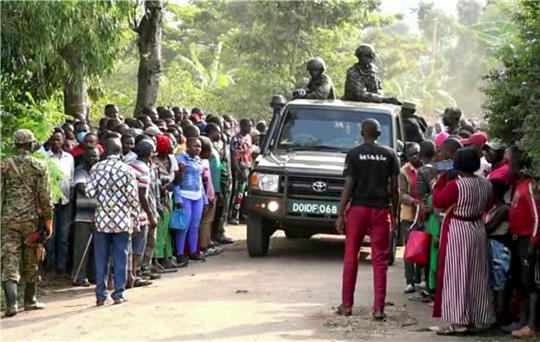 Ugandische Sicherheitskräfte fahren an einer Menschenmenge vorbei, die sich nach dem Angriff vor der Schule in Mpondwe versammelt hat (Videostandbild).