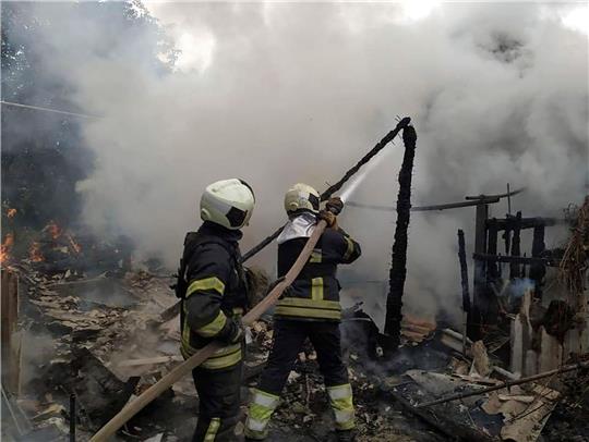 Ukrainische Feuerwehrleute löschen einen Brand in einem beschädigten Wohnhaus in Lyssytschansk.