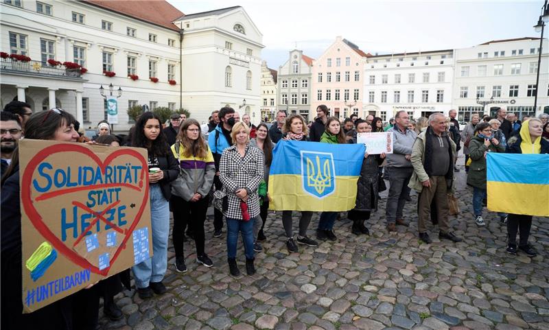 Ermittlungen laufen nach Brand in Flüchtlingsunterkunft Ukrainische Frauen und weitere Teilnehmer stehen bei einer Mahnwache auf dem Wismarer Marktplatz.