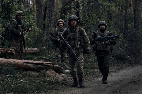Ukrainische Soldaten gehen in der Nähe der russischen Stellungen in der Region Luhansk durch den Wald.
