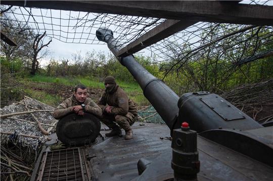 Ukrainische Soldaten schauen aus einer Panzerhaubitze.