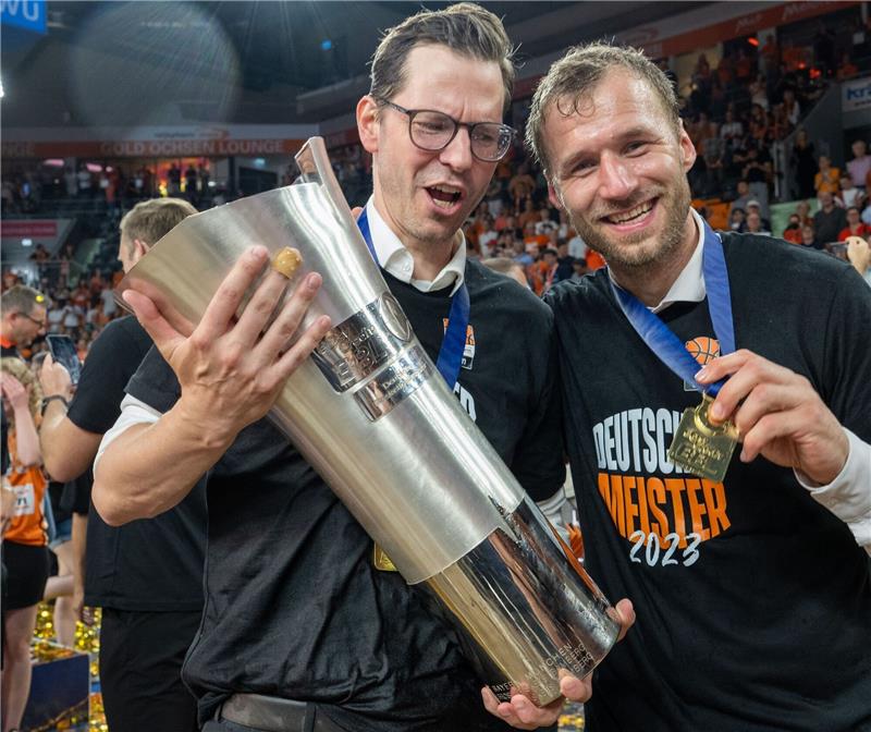 Ulms Trainer Anton Gavel (r) und Sportdirektor Thorsten Leibenath halten den Meisterpokal.